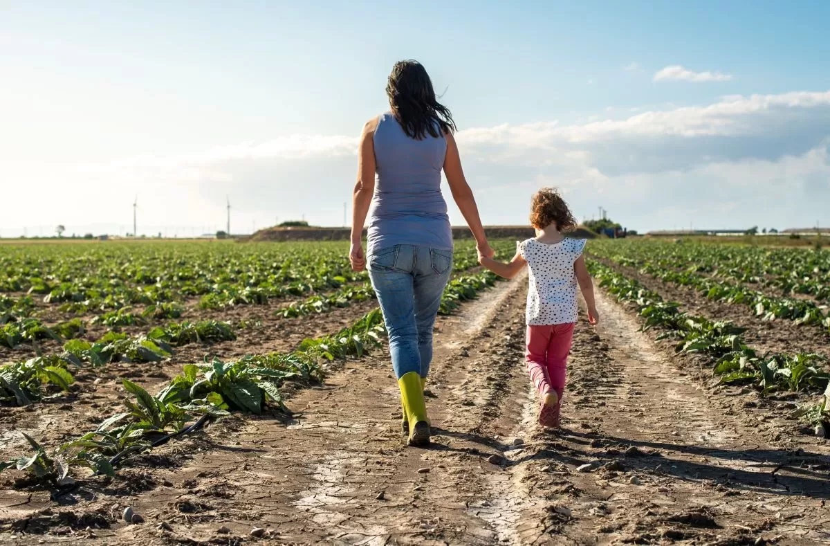 femme et fille marchent dans un champ